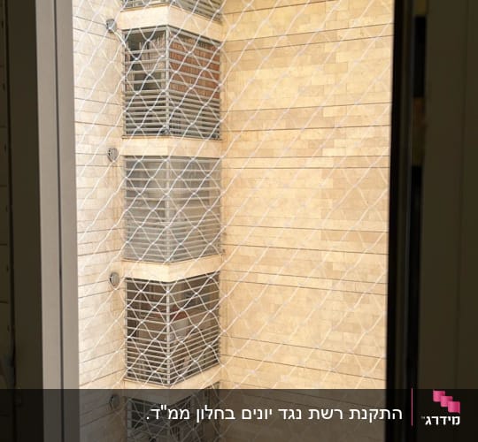 התקנת רשת שקופה נגד יונים בפתח מסתור כביסה בבניין
